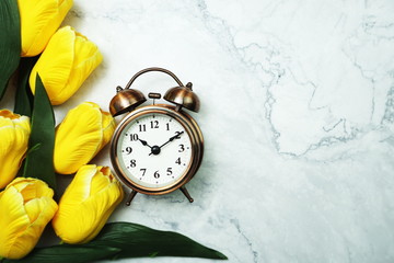 Vintage Alarm Clock And Tulip Bouquet with space copy on marble background