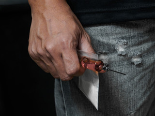 The male drug addict is about to use a drug syringe