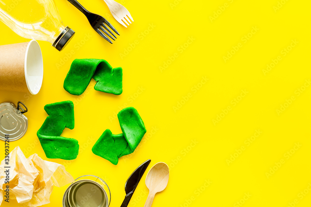 Canvas Prints Green recycle icon near plastic, paper, glass waste on yellow background top-down copy space