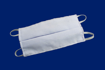 White cloth mask on a blue background Help prevent dust and germs. Covid-19