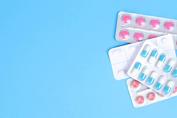 Plates of multi-colored tablets on a blue background.