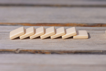 Domino effect in business or education, stacked blocks fall down on rustic background. 