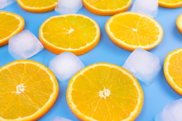  Slices of orange and ice cubes on a blue background.Summer background.