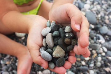 heart shaped small pebbles in children's hands