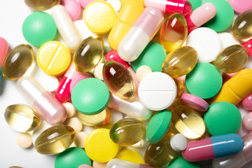 Many multi-colored pills on a white background close-up