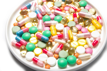 Pills lie in a white plate close-up. Health, medicine