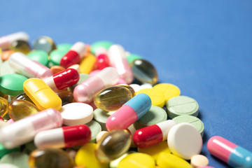 Pills and capsules on a blue background.Concept of medicine and health.