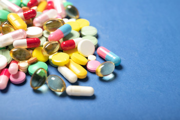 Pills and capsules on a blue background.Concept of medicine and health.