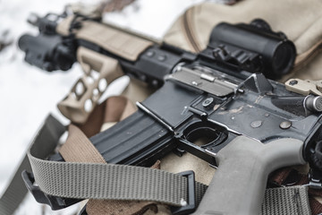 An assault rifle lies on a military briefcase.