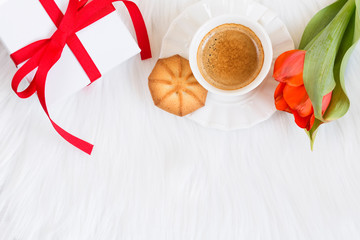 Romantic holiday concept: Red ribbon gift box and aromatic black coffee  on white background. Copy space.