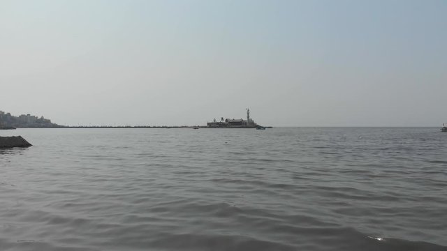 Drone shot flying towards Haji Ali dargah sea mosque at sea level