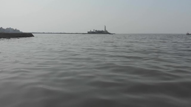Dolly drone shot towards and then rising over Haji Ali Dargah Sea mosque
