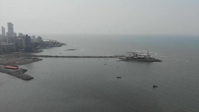 Dolly back drone shot of Haji Ali Dargah Mosque