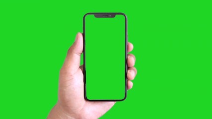 Man's hand holding a black smartphone with green screen and touching or press display, Man using mobile phone with chroma key touch display on green background. - Powered by Adobe