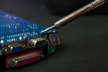 backdrop of smoking soldering iron on dark background