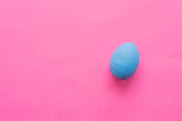 Blue Easter egg on a pink background.