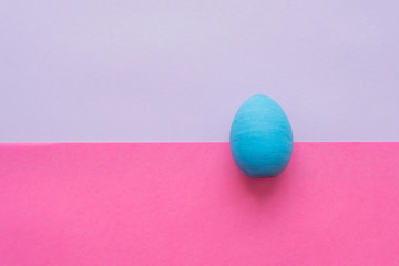 Blue Easter egg on a pink background.