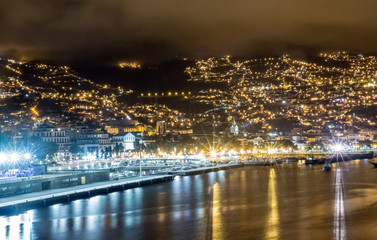 funchal, madeira, portugal view by night with clouds up the mountains