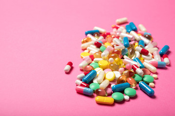 Pills and capsules on a pink background.Concept of medicine and health.