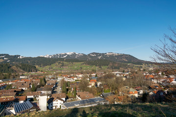 Obraz premium Blick über die Sonthofen auf die Berge. Die Stadt im Allgäu ist ein beliebtes Ziel von Urlaubern, die sich in den Alpen erholen möchten oder die sportliche Herausforderung suchen.