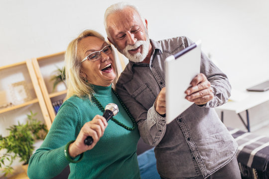 Senior Couple Singing Karaoke At Home, Having Fun.Quarantine.