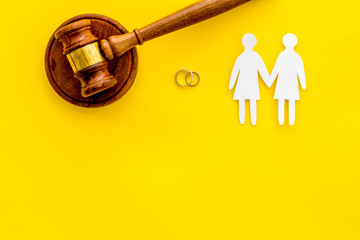 LGBT divorce. Judge gavel, rings, female couple on yellow background top-down copy space