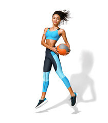 Sporty girl with medicine ball in motion. Photo of african american girl in fashionable sportswear on white background. Dynamic movement. Side view. Full length. Sports and healthy lifestyle