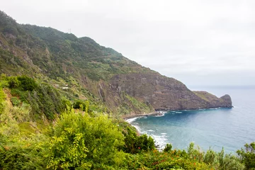 Fotobehang Dramatic coastal scenery of the village of Boaventura and the Arco de Sao Jorge mountain range on the north coast of the Portuguese Island of Madeira © Andreas
