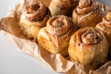 close up view of fresh delicious homemade cinnamon rolls on parchment paper