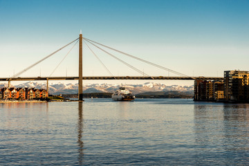A passenger regular ferry from Stavanger to Tau passes under a city bridge in Stavanger, Norway, December 2017