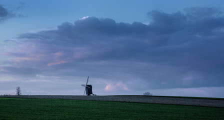 Fototapeta na wymiar Horebeke East Flanders Belgium. Sunset at field with windmill