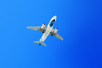 White airplane flies on clear blue sky background close up, passenger airliner takeoff, aviation banner, travel poster, vacation concept, international airlines business, tourist wallpaper, copy space