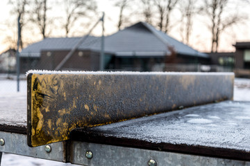 Fototapeta na wymiar Tiny icicles on a tennis table improvised board net in one of the outdoor parks in Stavanger city, Norway, December 2017