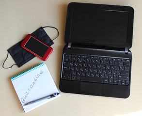 Laptop, notebook, smartphone, and medical mask. Work from home. Quarantine due to the pandemic of coronavirus Covid-19