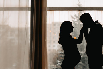 tender and sensual hugs of husband and his pregnant wife