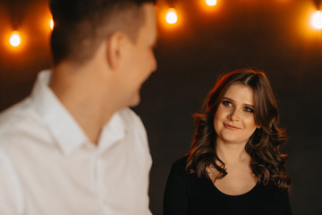 caring husband leads the hand of his pregnant wife in the studio