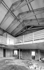 Inside of unfinished house with exposed timber trusses