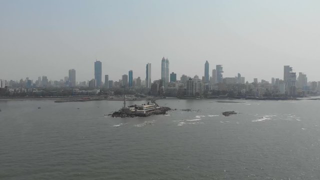 Rising drone shot of Haji Ali dargah sea mosque with Mumbai city in the background