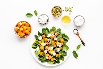 Salad with pumpkin and basil - near ingredients - on white background top-dow