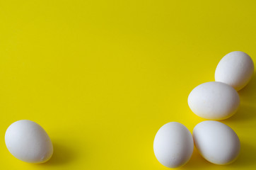 Chicken eggs on yellow background with copy space