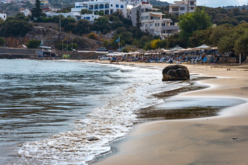 waves of the Mediterranean rush to the hot sandy beach in the Greek resort of Agios Nikolaos in...