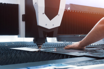 Man controls laser cutting of metal