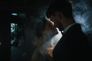 Obraz na płótnie Canvas wedding couple kisses in the smoke