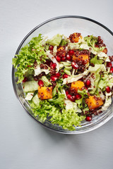Salad with lettuce, pumpkin, red quinoa and pomegranate.