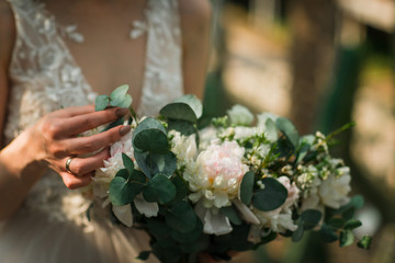 the bride holds a delicate wedding bouquet