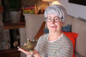 Senior woman rubbing genie lamp