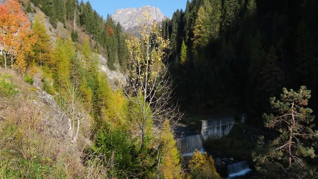 Autumn Dolomites scene with waterfall cascades on mountain river, Sudtirol, Italy. Picturesque traveling, seasonal, nature and countryside beauty concept scene.
