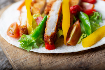 Mexican fajitas on a rustic wooden board with their ingredients