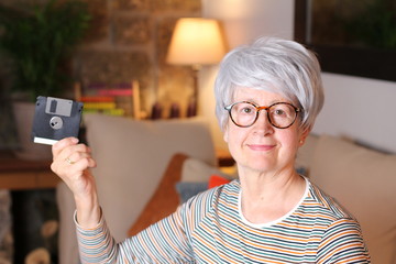 Senior woman holding floppy disk