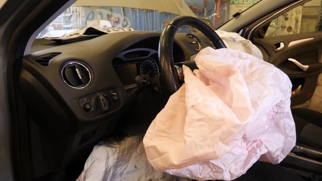 Vehicle airbag deployed to save the driver during a crash - after the accident view in the garage